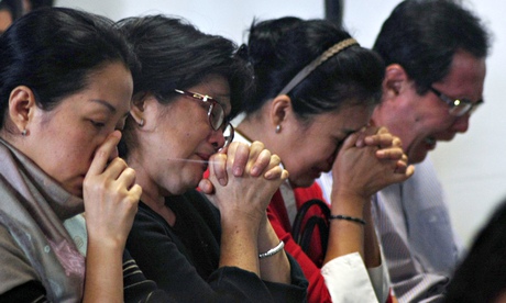 Relatives of Flight QZ8501 praying. Image courtesy of theguardian.com