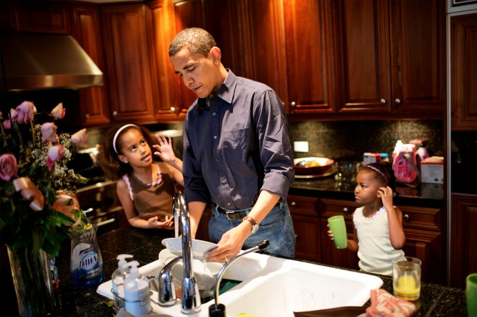 US Senator Barack Obama and his daughters (left) Malia, 8, and Sasha, 5, clean the dishes after breakfast at their home in Hyde Park - a suburb of Chicago, IL. The girls were getting ready to go to school.
